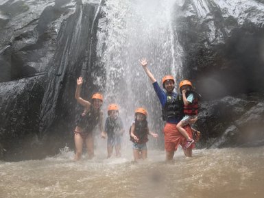 Familie unter einem Wasserfall – Indonesien Reise mit Kindern