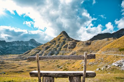 Eine einsame Bank steht alleine in der Natur mit einem traumhaften Blick in die Ferne