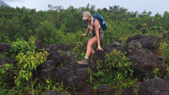 Wanderin auf schwarzem Lavagestein im Vulkan Arenal Nationalpark – Costa Rica Familienreise