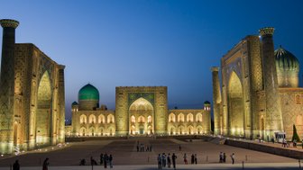 Die beeindruckende Architektur der Registan in Samarkand erstrahlt in warmem Licht, während Menschen die Szenerie genießen.