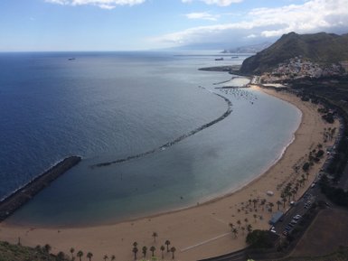 Eine atemberaubende Aussicht auf den Strand von Las Teresitas, umgeben von klarem Wasser und sanften Wellen.