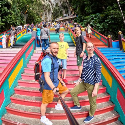 Familie hält den Moment mit einem Selfie auf der farbenfrohen Treppe der Batu-Höhlen fest – Malaysia & Borneo Familienreise