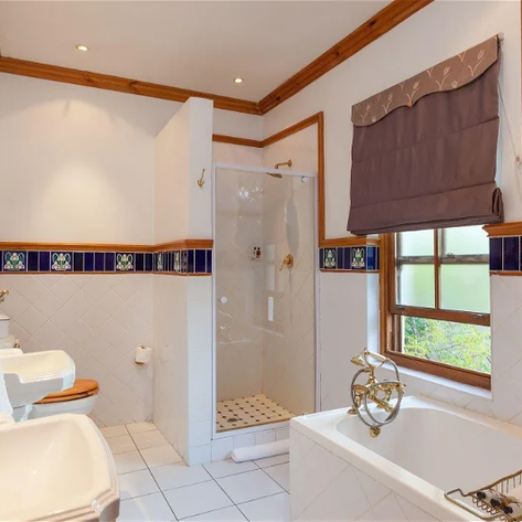 Ein elegantes Badezimmer mit einer Badewanne, einer Dusche und stilvollen Armaturen, umgeben von warmen Holzelementen.