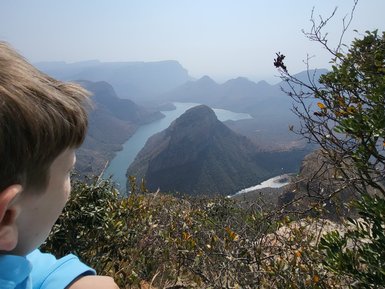 Ein Kind steht am Rand des Blyde River Canyons und blickt fasziniert auf die Landschaft – Südafrika mit Kindern