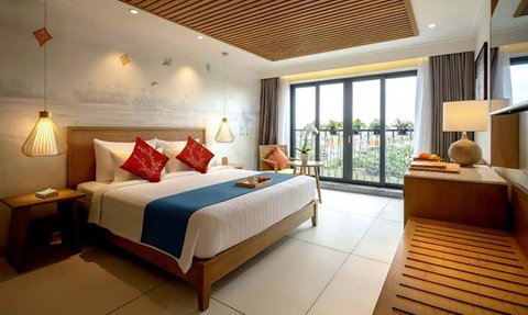 Ein elegantes Schlafzimmer mit einem großen Bett, dekoriert mit roten Kissen und einer blauen Decke, strahlt Ruhe aus.