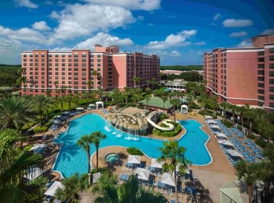 Ein Blick auf den großzügigen Poolbereich des Caribe Royal Resorts, umgeben von Palmen und Sonnenliegen unter klarem Himmel.