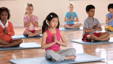 Kinder praktizieren Yoga in einer friedlichen Umgebung – Bali Familienreise