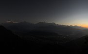 Ein atemberaubender Blick auf die schneebedeckten Berge Nepals bei Sonnenuntergang, der den Himmel in warmen Farben erleuchtet.