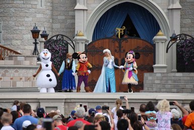 Eine Gruppe von Disney-Charakteren, darunter Elsa und Mickey Mouse, steht auf einer Bühne im Magic Kingdom.