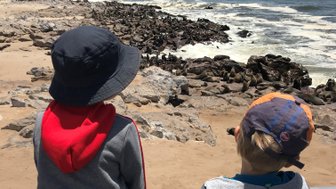 Zwei Kinder beobachten eine Robbenkolonie - Namibia mit Jugendlichen