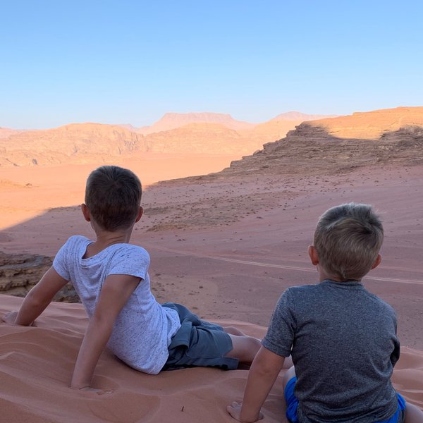 Kinder sitzen auf Düne im Wadi Rum - Jordanien mit Kindern