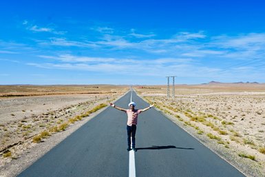Guide steht lächelnd für ein Bild auf einer Landstraße in der Nähe des Iriki-Sees – Marokko Familienreise