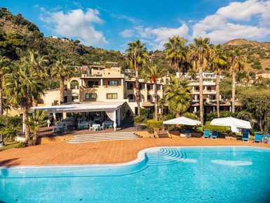 Ein sonniger Tag am Hotel Aktea auf Lipari, umgeben von Palmen und einem einladenden Poolbereich.
