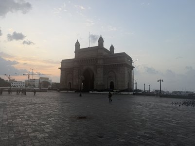 Das beeindruckende Gateway of India erhebt sich majestätisch im Dämmerlicht, umgeben von einer ruhigen Platzlandschaft.