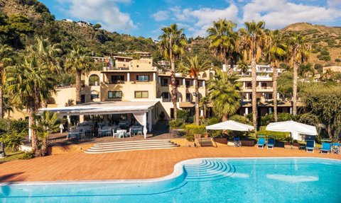Ein sonniger Tag am Hotel Aktea auf Lipari, umgeben von Palmen und einem einladenden Poolbereich.