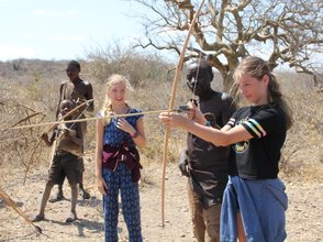 Jugendliche des Hadzabe-Stamms übt Bogenschießen – Tansania mit Kindern