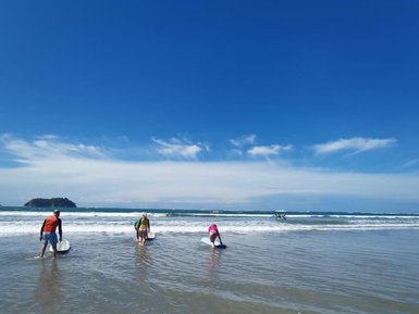 Familie hat Spaß beim gemeinsamen Surfen in Costa Rica – Costa Rica Reise mit Kindern