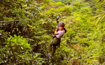 Ein mutiges Mädchen gleitet an einer Zipline durch die Baumwipfel des Regenwaldes – Costa Rica Familienreise