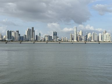 Die Skyline von Panama City zeigt beeindruckende Wolkenkratzer, reflektierend im stillen Wasser des Meeres.