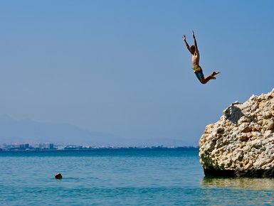 Kind springt ins Wasser am Strand vom Crowne Plaza Muscat – Oman Reise mit Kindern