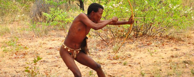 Ein Mann schießt mit einem kleinen Bogen - Namibia Urlaub mit Kindern