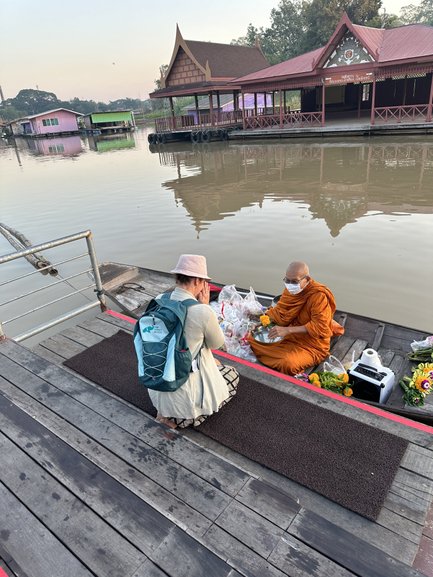 Touristin spricht mit Mönch, der in einem Boot sitzt in Uthai Thani- Thailand Familienreise