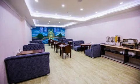 Ein eleganter Restaurantbereich mit blauen Sofas und Holztischen, der eine einladende Atmosphäre ausstrahlt.