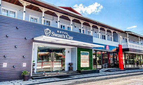 Das Hotel Swan's Cay präsentiert sich mit einer einladenden Fassade und einem klaren blauen Himmel im Hintergrund.