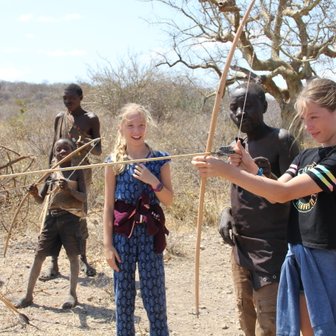 Jugendliche des Hadzabe-Stamms übt Bogenschießen – Tansania mit Kindern