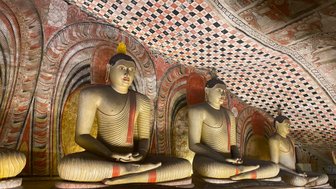 Mehrere nebeneinander sitzende Buddha-Statuen im Dambulla-Höhlentempel – Sri Lanka Familienreise