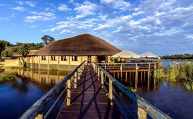 Lodge mit Reetdach, direkt am Wasser gelegen, mit Steg und Terrasse über dem Fluss - Namibia Familienreise