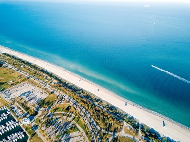 Eine Luftaufnahme zeigt die Küste von Miami mit feinem Sandstrand und klarem, blauem Wasser, ideal für Erholung.