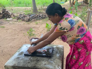 Frau macht in der Nähe von Sigiriya ein traditionelles Gericht – Sri Lanka Familienreise