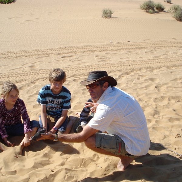 Zwei Kinder und ein Mann sitzen im Sand - Namibia Familienurlaub