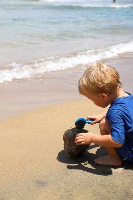 Kleines Kind spielt fröhlich im Sand am Strand – Costa Rica Familienreise