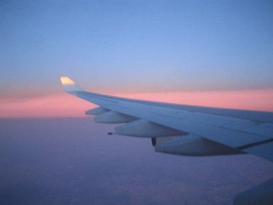 Blick aus dem Flugzeugfenster auf den strahlenden Sonnenaufgang – Südafrika Reise mit Kindern