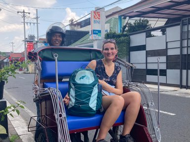 Eine Frau genießt die Fahrt im bunten Tuk-Tuk – Indonesien Familienreise