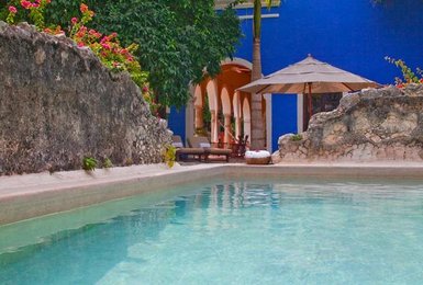 Ein ruhiger Poolbereich mit klarem Wasser, umgeben von üppigem Grün und bunten Blumen, ideal zum Entspannen.