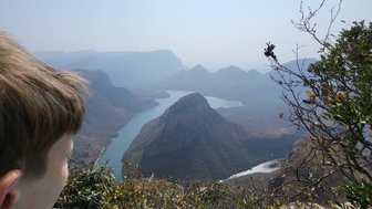 Ein Kind steht am Rand des Blyde River Canyons und blickt fasziniert auf die Landschaft – Südafrika mit Kindern