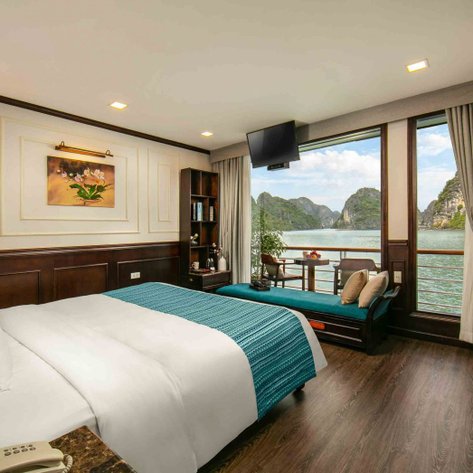 Ein elegantes Zimmer auf einem Kreuzfahrtschiff mit Blick auf die Halong-Bucht, ausgestattet mit modernen Möbeln und Dekoration.