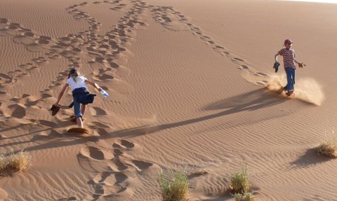 Zwei Kinder spielen auf einer Sanddüne - Namibia Rundreise mit Kindern
