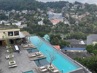 Ein atemberaubender Blick auf einen Infinity-Pool, umgeben von modernen Terrassen und üppiger grüner Landschaft.