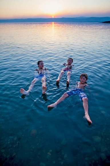 Familie im Toten Meer bei Sonnenuntergang