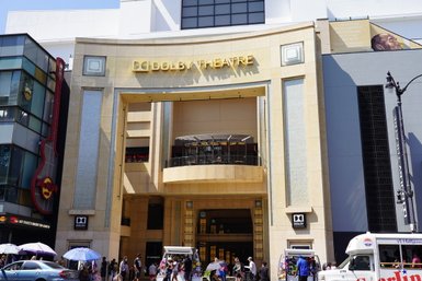 Der Eingang zum Dolby Theatre in Hollywood, umgeben von Menschen und bunten Verkaufsständen, strahlt ein lebhaftes Ambiente aus.
