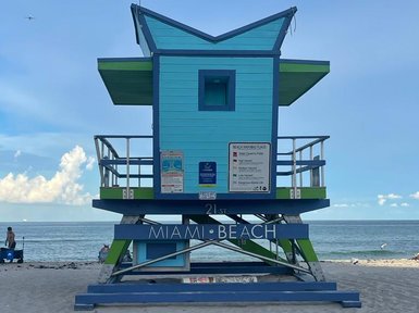 Ein farbenfroher Rettungsschwimmerturm steht am Strand von Miami Beach, umgeben von feinem Sand und dem glitzernden Wasser.