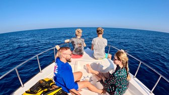 Familie im Boot auf dunkelblauem Wasser bei den Daymaniyat Inseln – Oman Familienreise