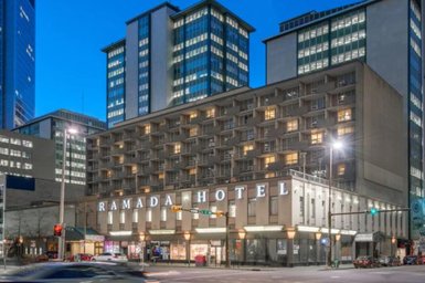 Das Ramada Hotel in Calgary zeigt eine moderne Architektur mit beleuchteten Fenstern und einem klaren Abendhimmel.
