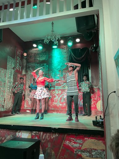 Eine Gruppe von Tänzern steht auf einer Bühne