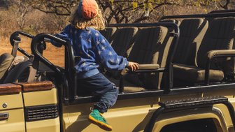 Kind sitzt auf einem Safari-Jeep in der Kubu Safari Lodge in Hoedspruit – Südafrika mit Kindern