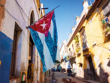 Eine große kubanische Flagge weht an einem Gebäude in einer Straße von Havanna